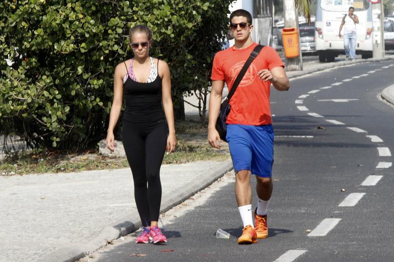 Enzo Celulari corre com a namorada em orla da praia no Rio