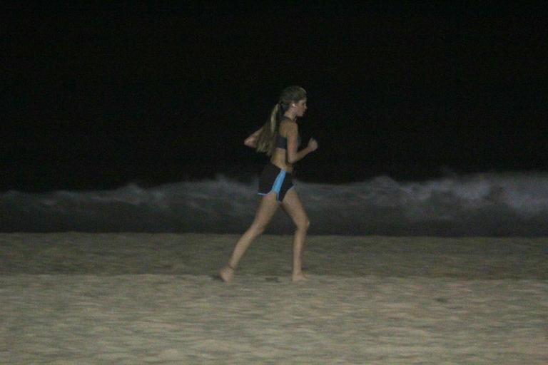 Bárbara Evans corre na praia durante a noite e mostra boa forma