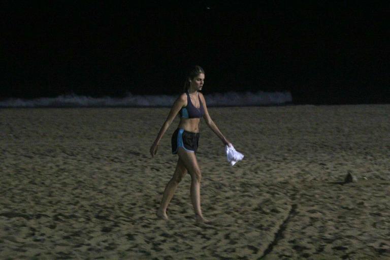 Bárbara Evans corre na praia durante a noite e mostra boa forma