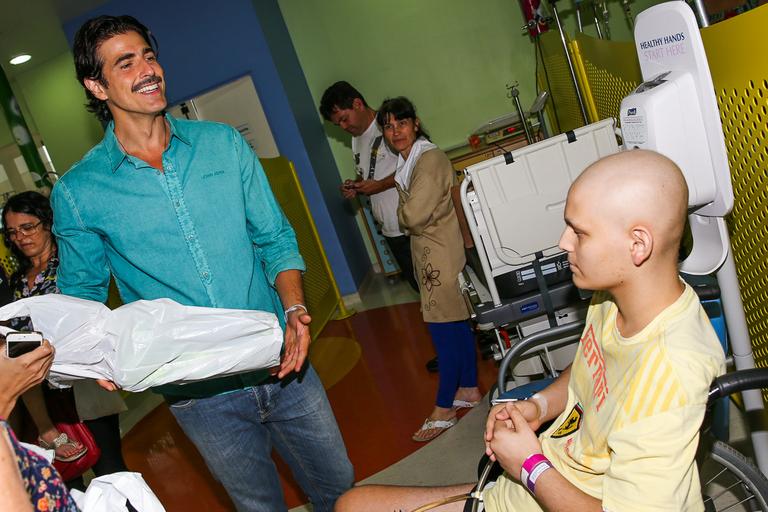 Reynaldo Gianecchini visita crianças, distribui presentes e tira fotos no hospital do GRAAC