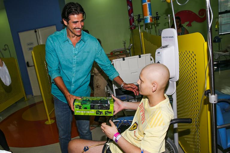 Reynaldo Gianecchini visita crianças, distribui presentes e tira fotos no hospital do GRAAC