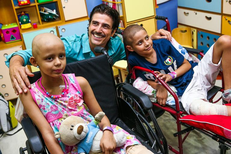 Reynaldo Gianecchini visita crianças, distribui presentes e tira fotos no hospital do GRAAC