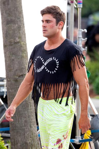 Zac Efron surge de top cropped em set de filmagem