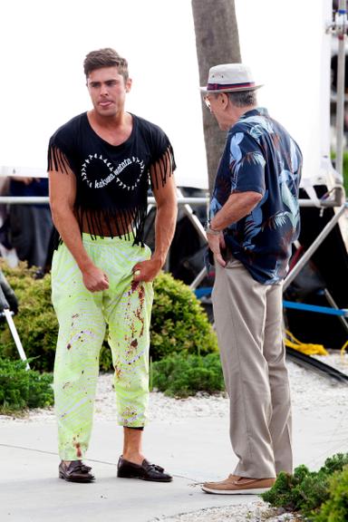 Zac Efron surge de top cropped em set de filmagem