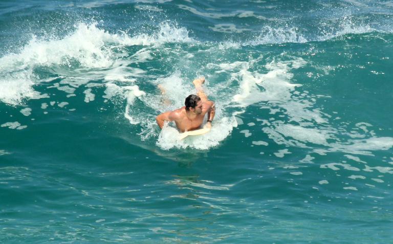 Flávio Canto exibe tanquinho em dia de surfe na praia