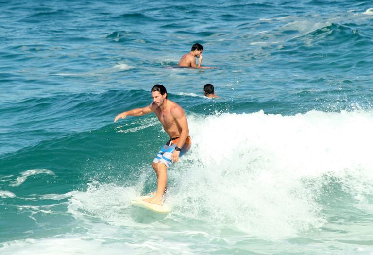 Flávio Canto exibe tanquinho em dia de surfe na praia