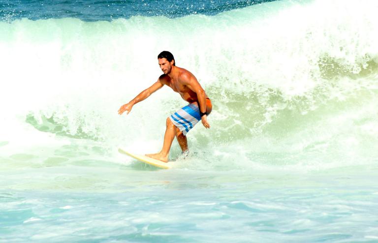 Flávio Canto exibe tanquinho em dia de surfe na praia