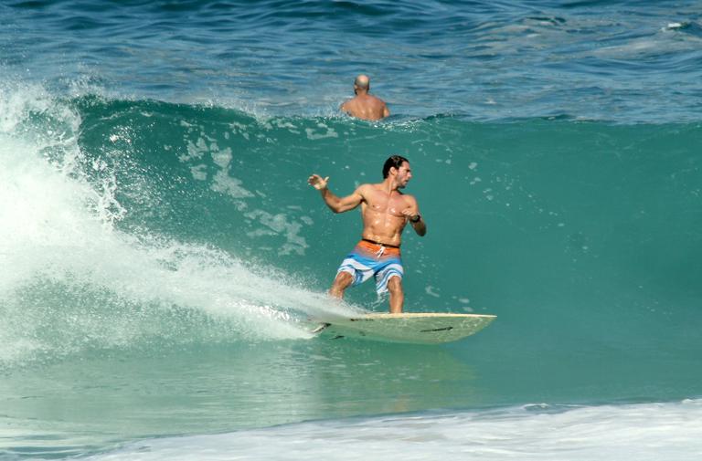 Flávio Canto exibe tanquinho em dia de surfe na praia