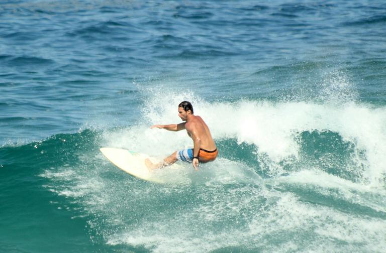 Flávio Canto exibe tanquinho em dia de surfe na praia