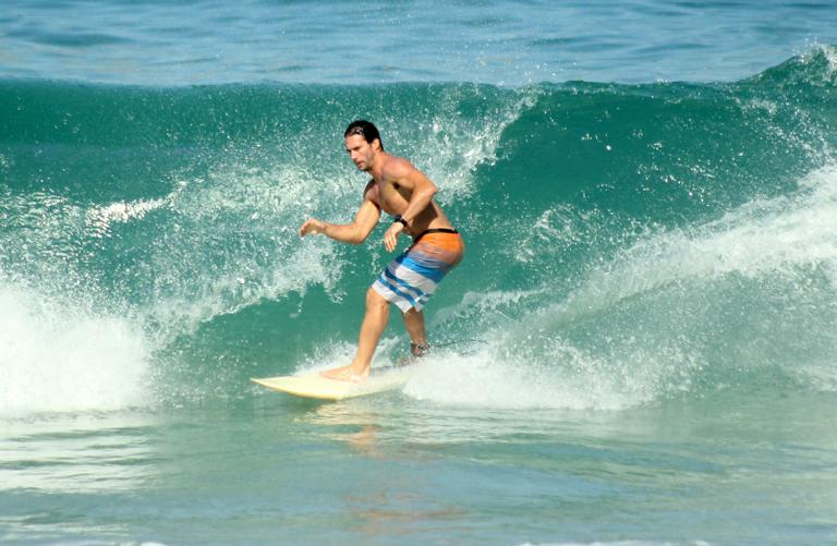 Flávio Canto exibe tanquinho em dia de surfe na praia