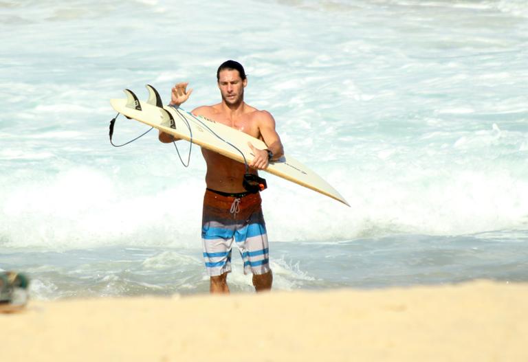 Flávio Canto exibe tanquinho em dia de surfe na praia