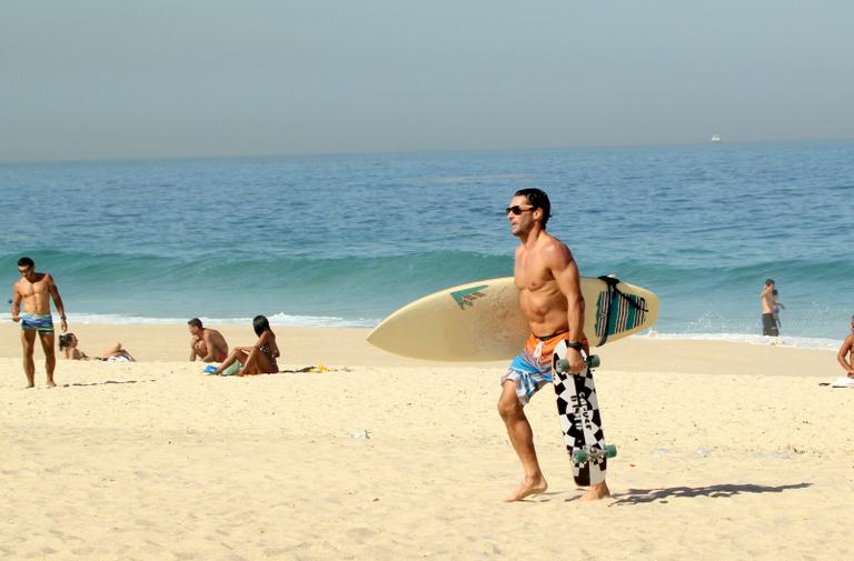 Flávio Canto exibe tanquinho em dia de surfe na praia