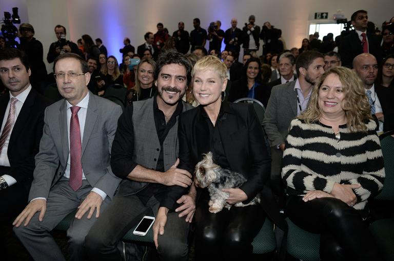 Xuxa e Junno Andrade levam cachorrinho em evento empresarial 