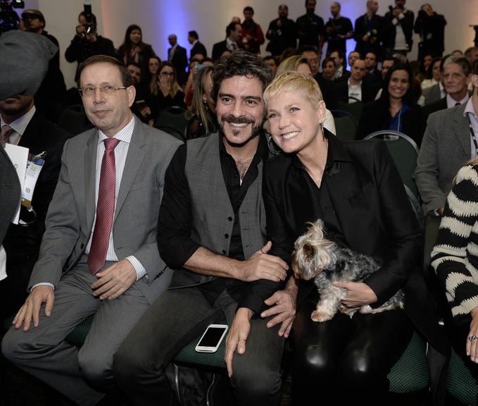 Xuxa e Junno Andrade levam cachorrinho em evento empresarial 