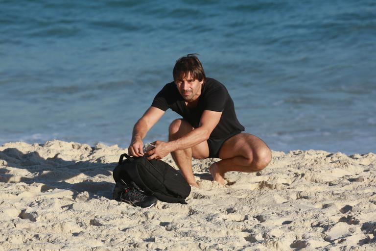 Sem desgrudar do celular, Murilo Rosa curte dia de praia no Rio de Janeiro