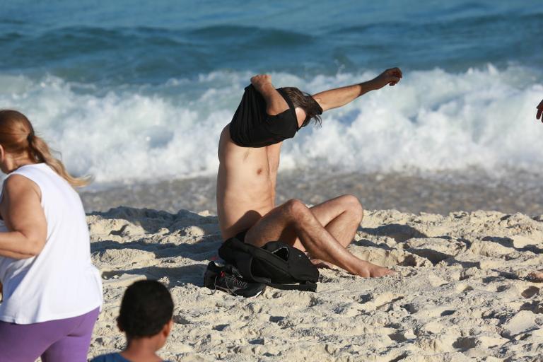 Sem desgrudar do celular, Murilo Rosa curte dia de praia no Rio de Janeiro