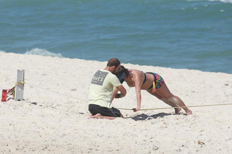 Deborah Secco exibe barrigão durante treino na praia