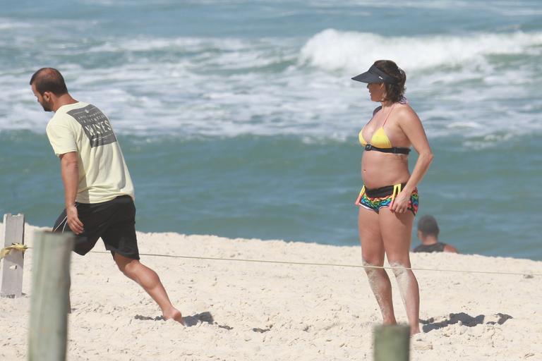 Deborah Secco exibe barrigão durante treino na praia