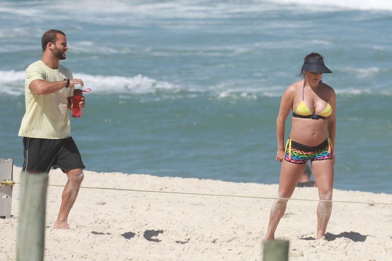 Deborah Secco exibe barrigão durante treino na praia