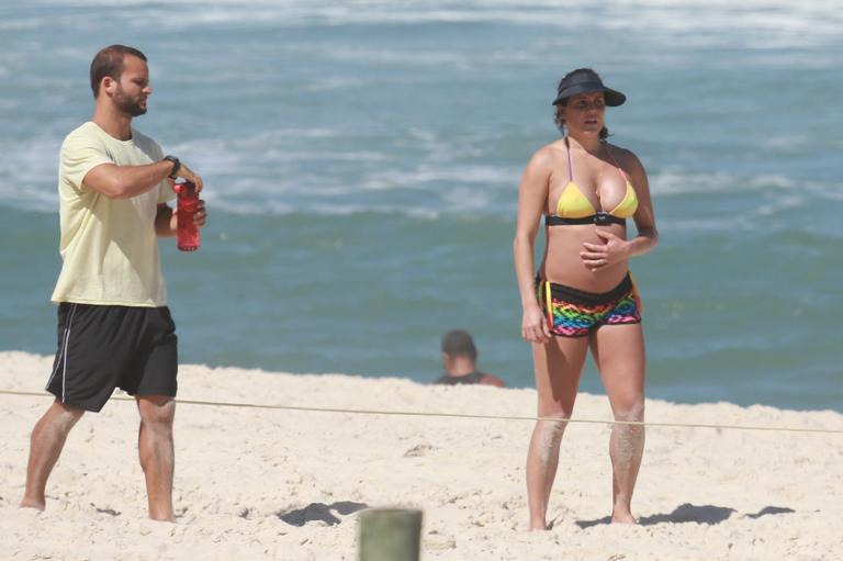 Deborah Secco exibe barrigão durante treino na praia