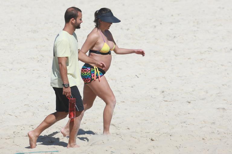 Deborah Secco exibe barrigão durante treino na praia