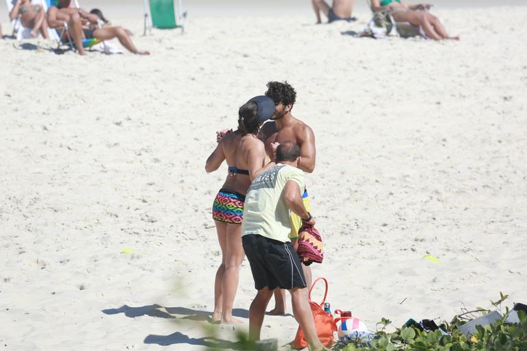 Deborah Secco recebe o carinho de Hugo Moura durante malhação na praia