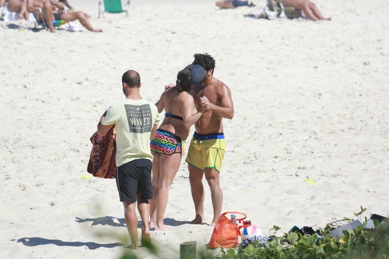 Deborah Secco recebe o carinho de Hugo Moura durante malhação na praia