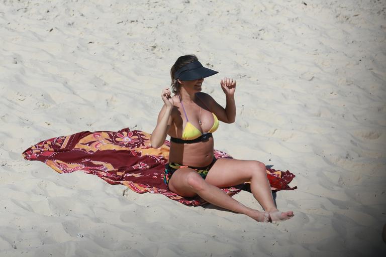 Deborah Secco exibe barrigão durante treino na praia