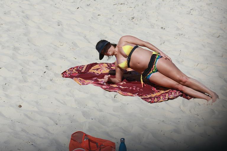 Deborah Secco exibe barrigão durante treino na praia