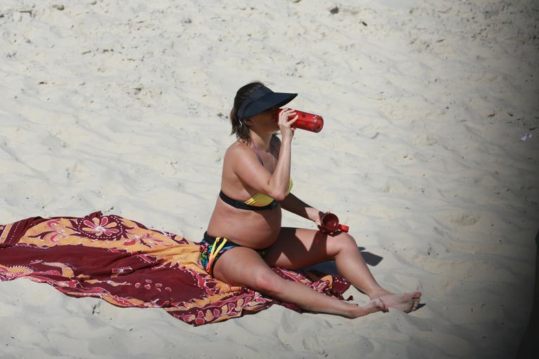 Deborah Secco exibe barrigão durante treino na praia