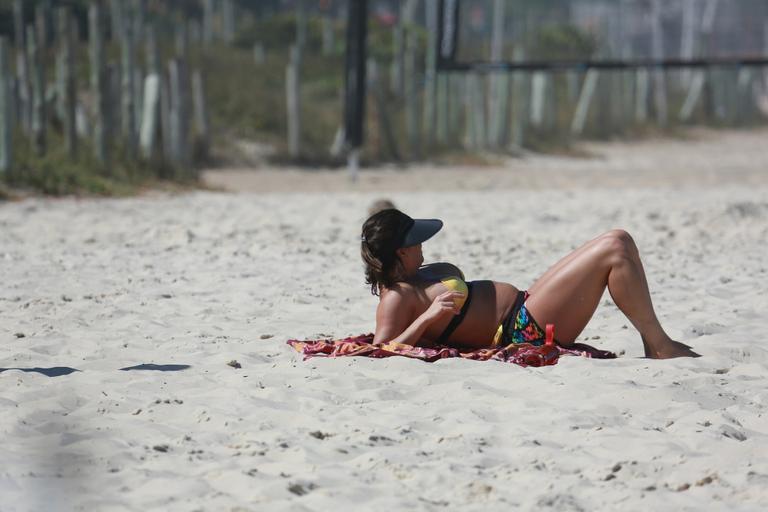 Deborah Secco exibe barrigão durante treino na praia