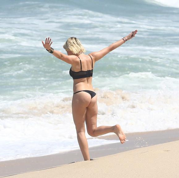 De biquíni, Bruna Linzmeyer grava cenas de A Regra do Jogo em praia no Rio