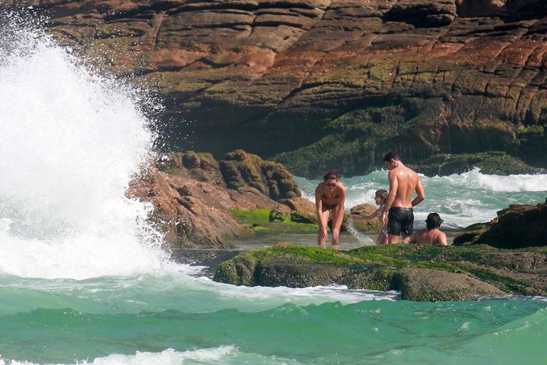 Cauã Reymond curte praia com Mariana Goldfarb e Sophia