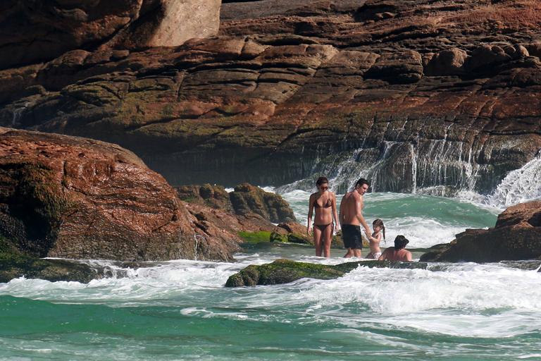 Cauã Reymond curte praia com Mariana Goldfarb e Sophia