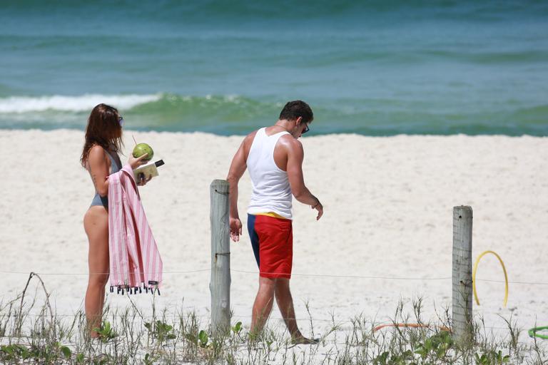 Em dia de sol, Cauã Reymond e namorada curtem praia no Rio