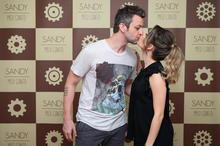 Sandy recebe o carinho do marido em show