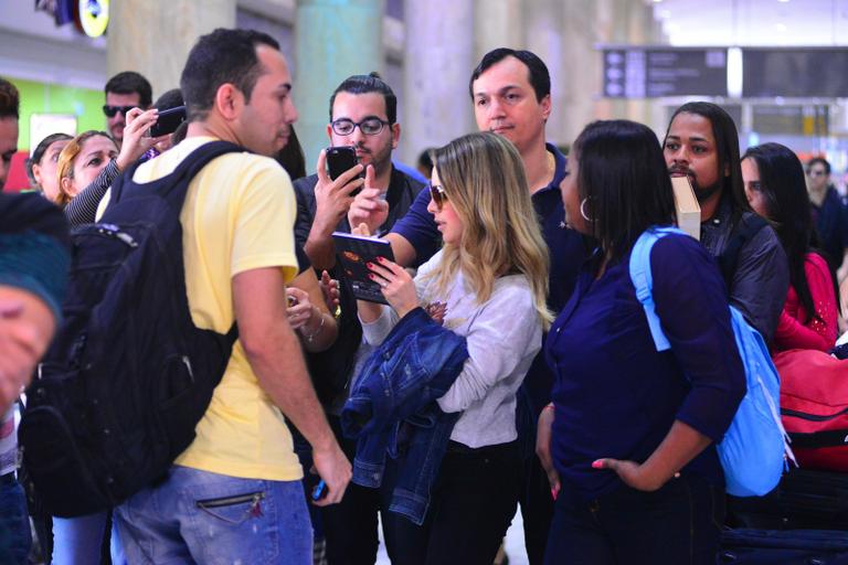 Sandy é recebida por fãs em aeroporto