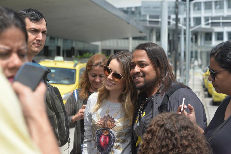 Sandy é recebida por fãs em aeroporto