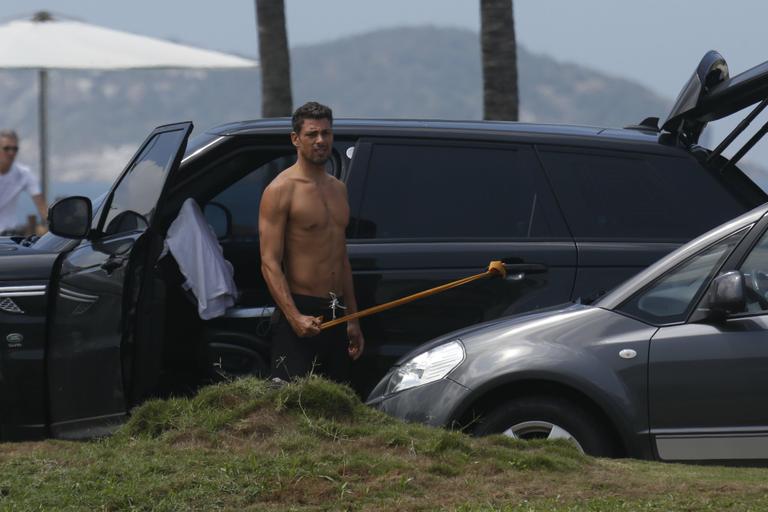 Sem camisa, Cauã Reymond faz exercícios na orla da praia