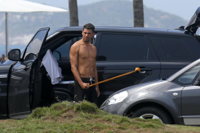 Sem camisa, Cauã Reymond faz exercícios na orla da praia