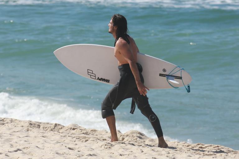 De cabelo solto, Tiago Iorc surfa no Rio e exibe boa forma ao trocar de roupa na rua