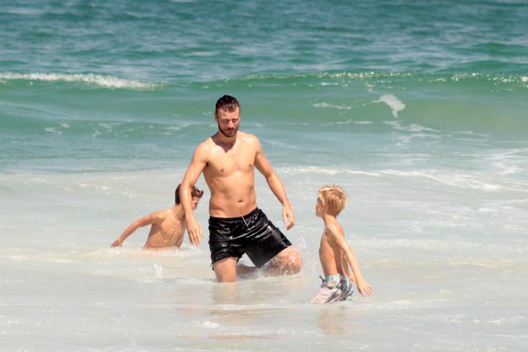 Rodrigo Hilbert curte dia na praia com os filhos gêmeos