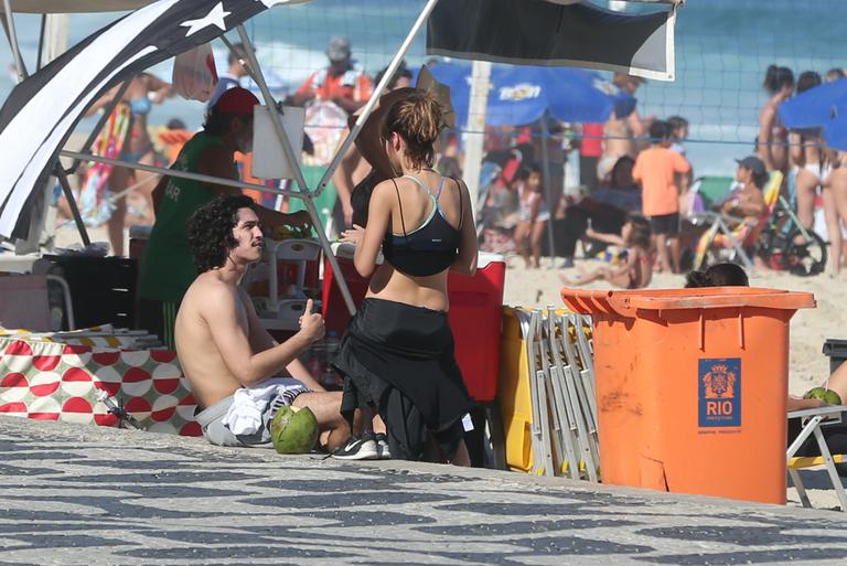 Gabriel Leone e Carla Salle trocam beijos na praia