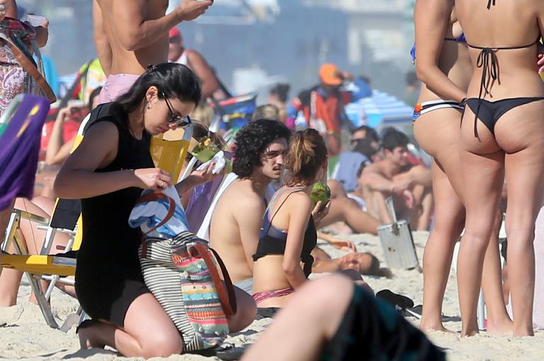 Gabriel Leone e Carla Salle trocam beijos na praia