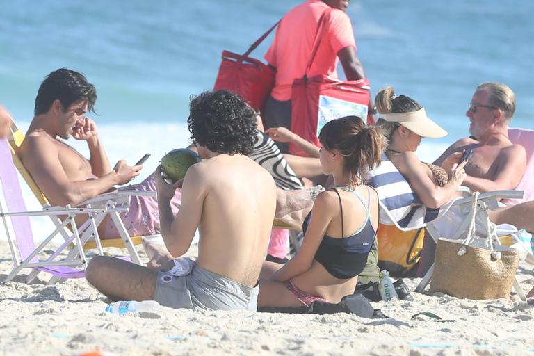 Gabriel Leone e Carla Salle trocam beijos na praia