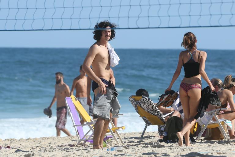 Gabriel Leone e Carla Salle trocam beijos na praia