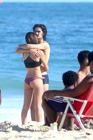 Gabriel Leone e Carla Salle trocam beijos na praia