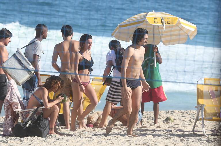 Gabriel Leone e Carla Salle trocam beijos na praia