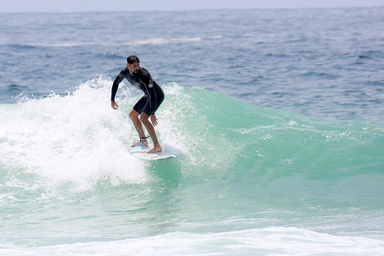 Cauã Reymond e José Loreto surfam em praias cariocas