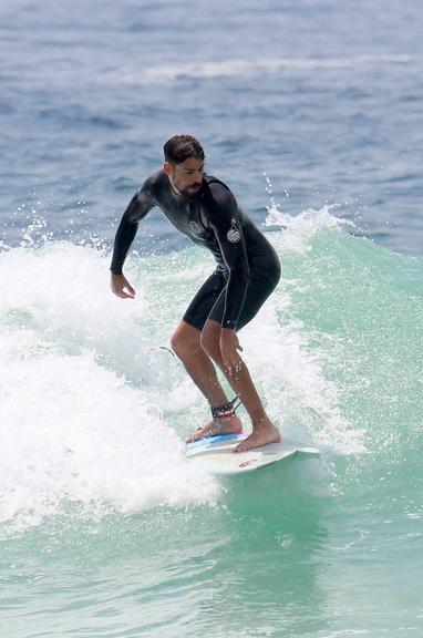 Cauã Reymond e José Loreto surfam em praias cariocas